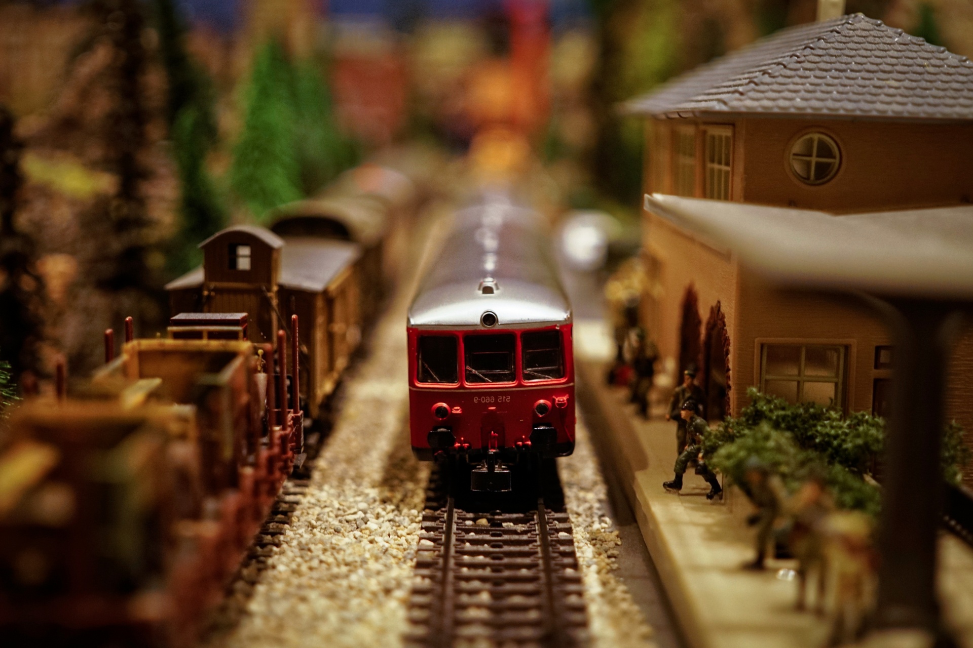 A red model train coming towards the camera